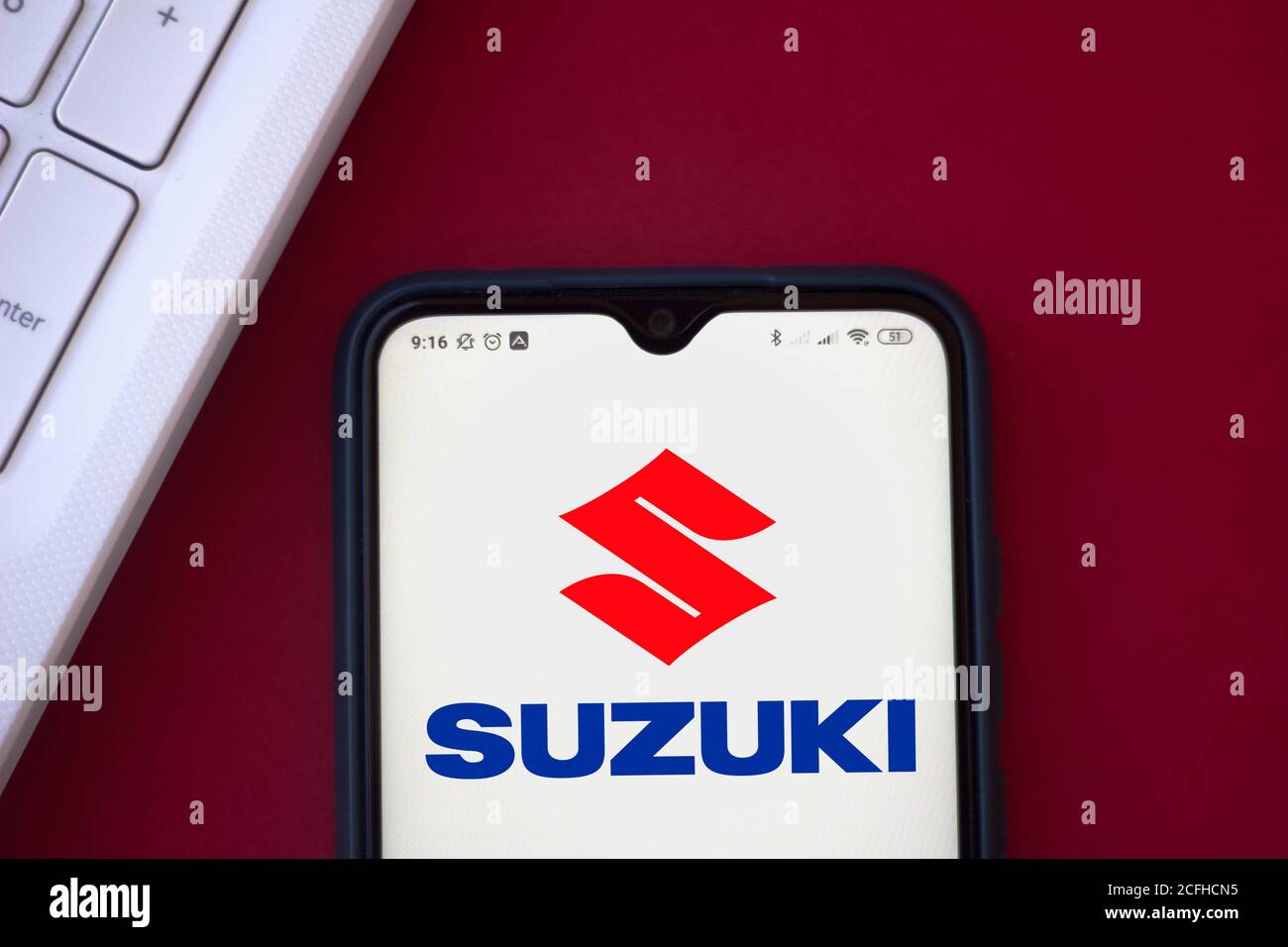 In this photo illustration the Suzuki logo seen displayed on a smartphone. Stock Photo