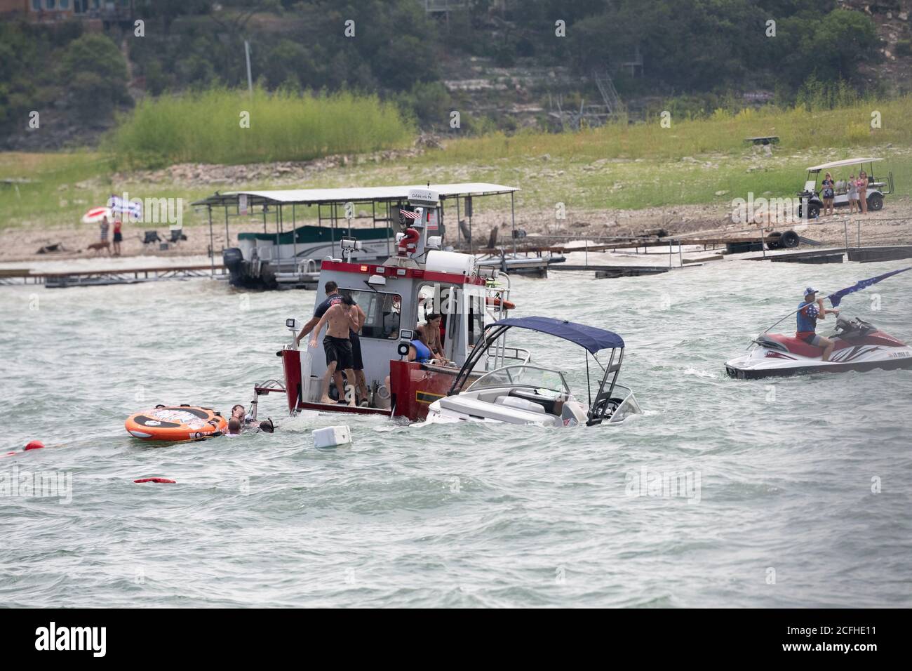 Lakeway, Texas USA Sept. 5, 2020: A small pleasure boat sits partially submerged after being swamped by large waves kicked up by wakes from water crafts participating in a pro-Donald Trump boat parade on Lake Travis. A total of five boats were swamped or sunk during the Labor Day Weekend event, which attracted hundreds of boaters. Stock Photo