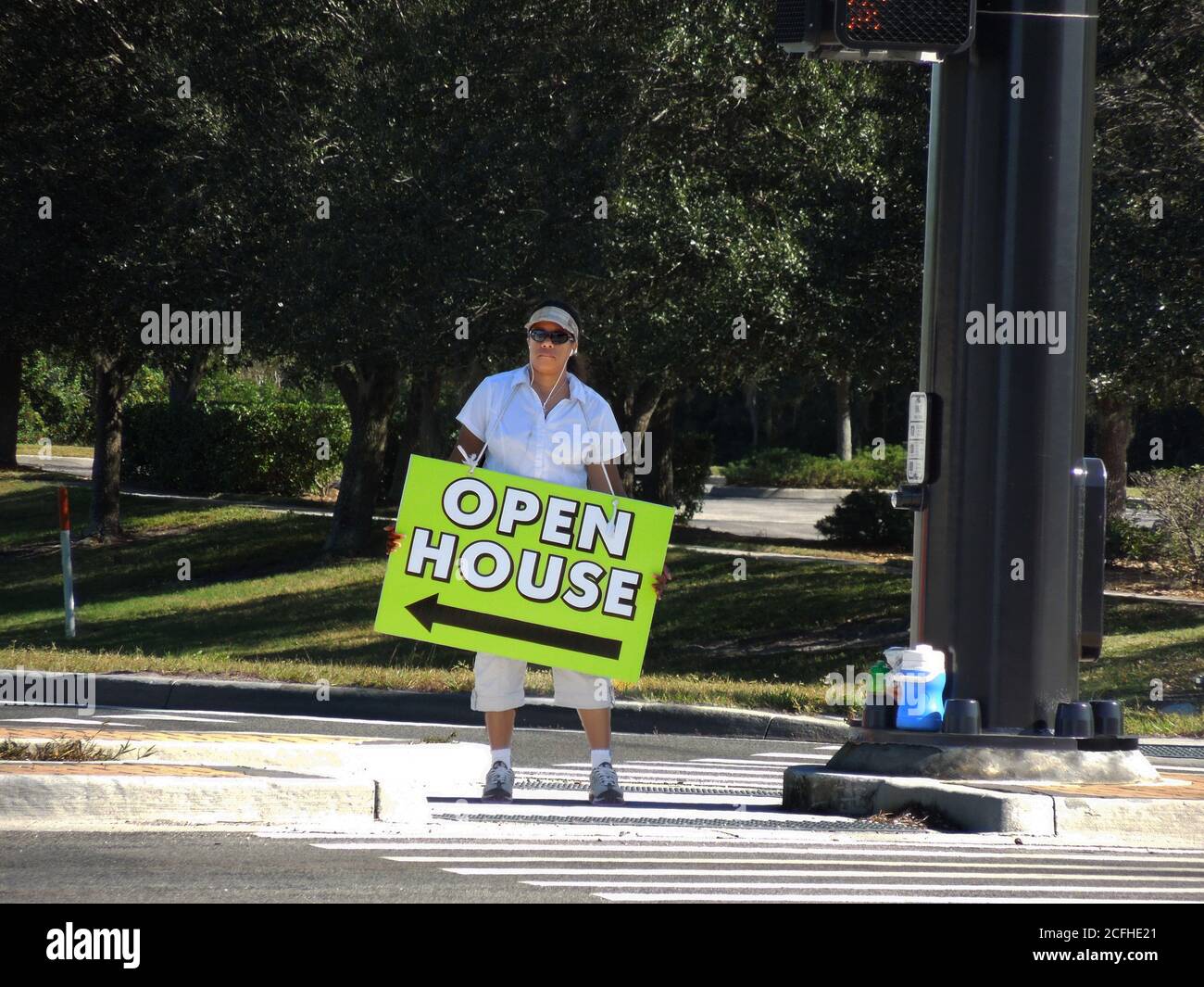 Black minority man holdiing open house sign for new or used or previously own home or house Stock Photo