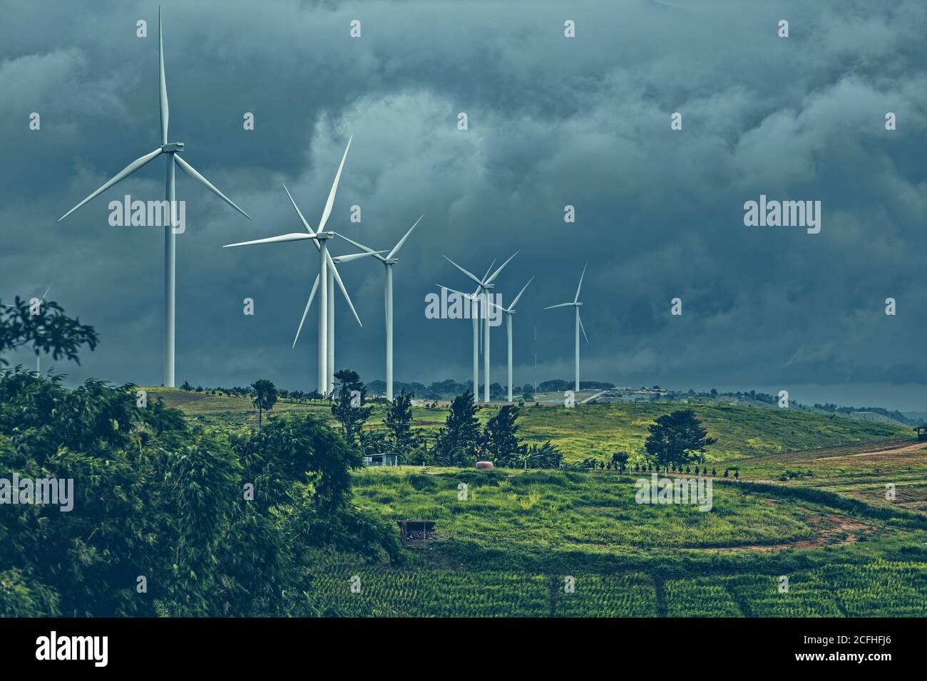 wind turbine on mountain and rain cloud. Stock Photo