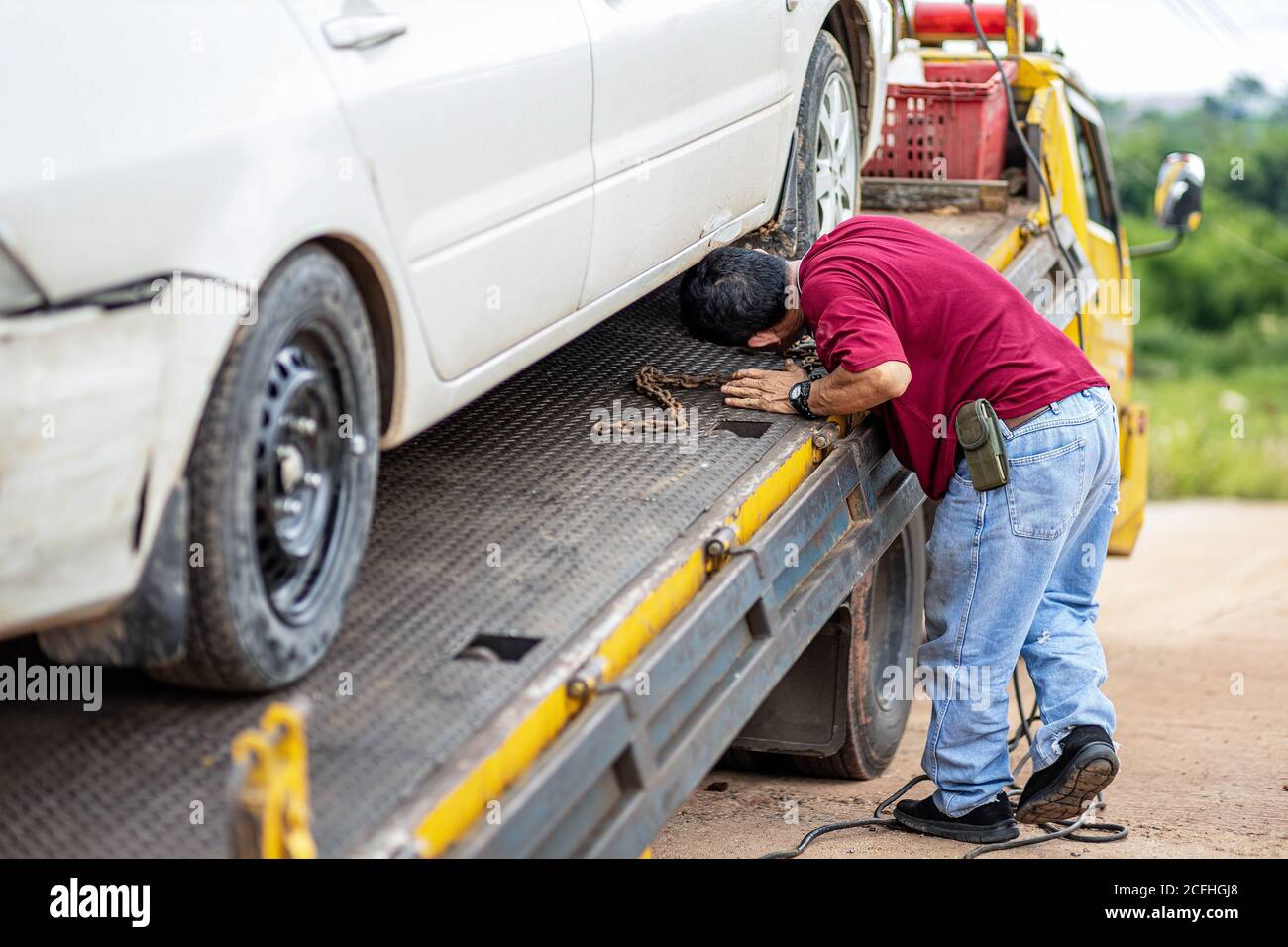 A man check chain bind car wheel on car tow in the park. Damage and
