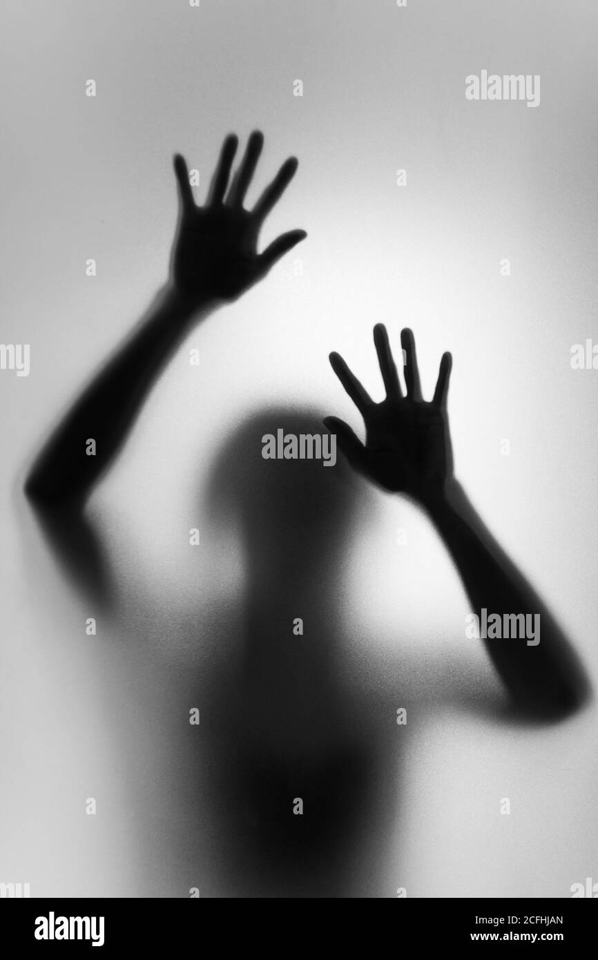 Ghost concept shadow of a woman behind the matte glass blurry hand and body soft focus Stock Photo