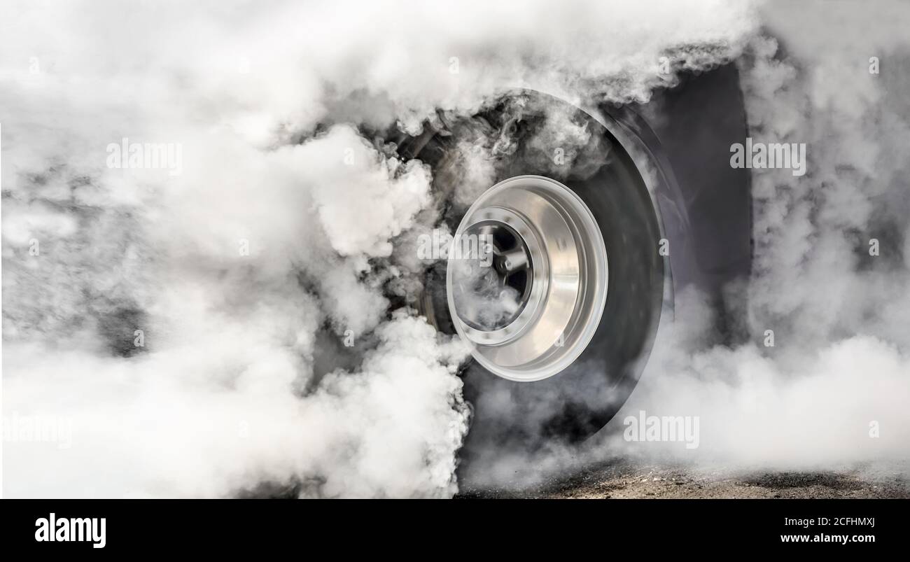 Drag racing car burns rubber off its tires in preparation for the race ...
