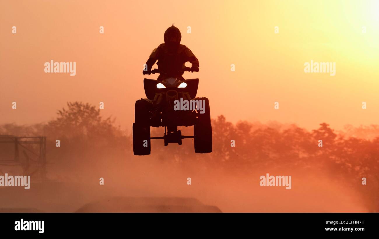 Silhouette ATV or Quad bikes Jump in the sunset. Stock Photo