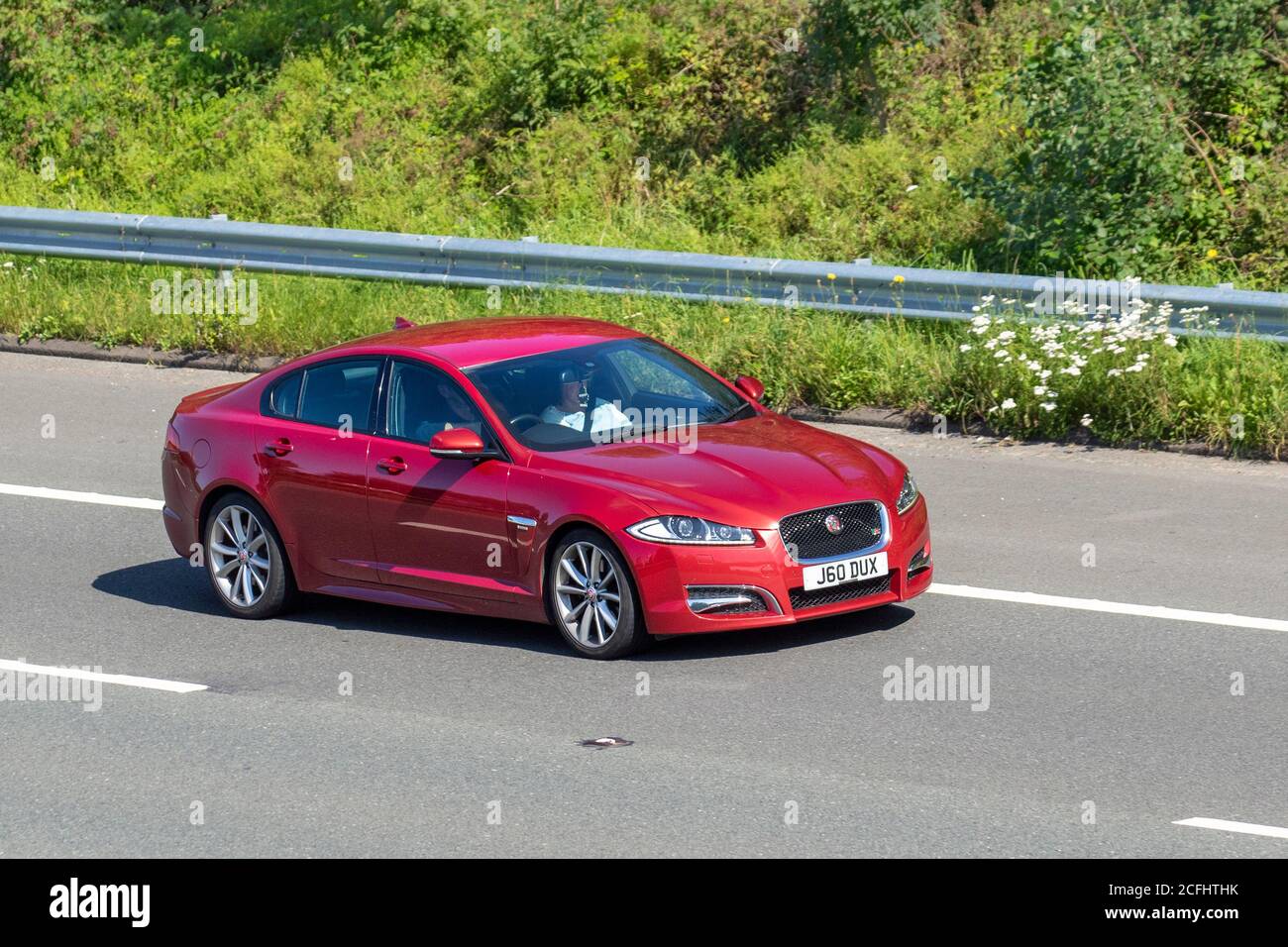 2013 red Jaguar XF R-Sport D Auto; Vehicular traffic moving vehicles, cars driving vehicle on UK roads, motors, motoring on the M6 motorway highway network. Stock Photo