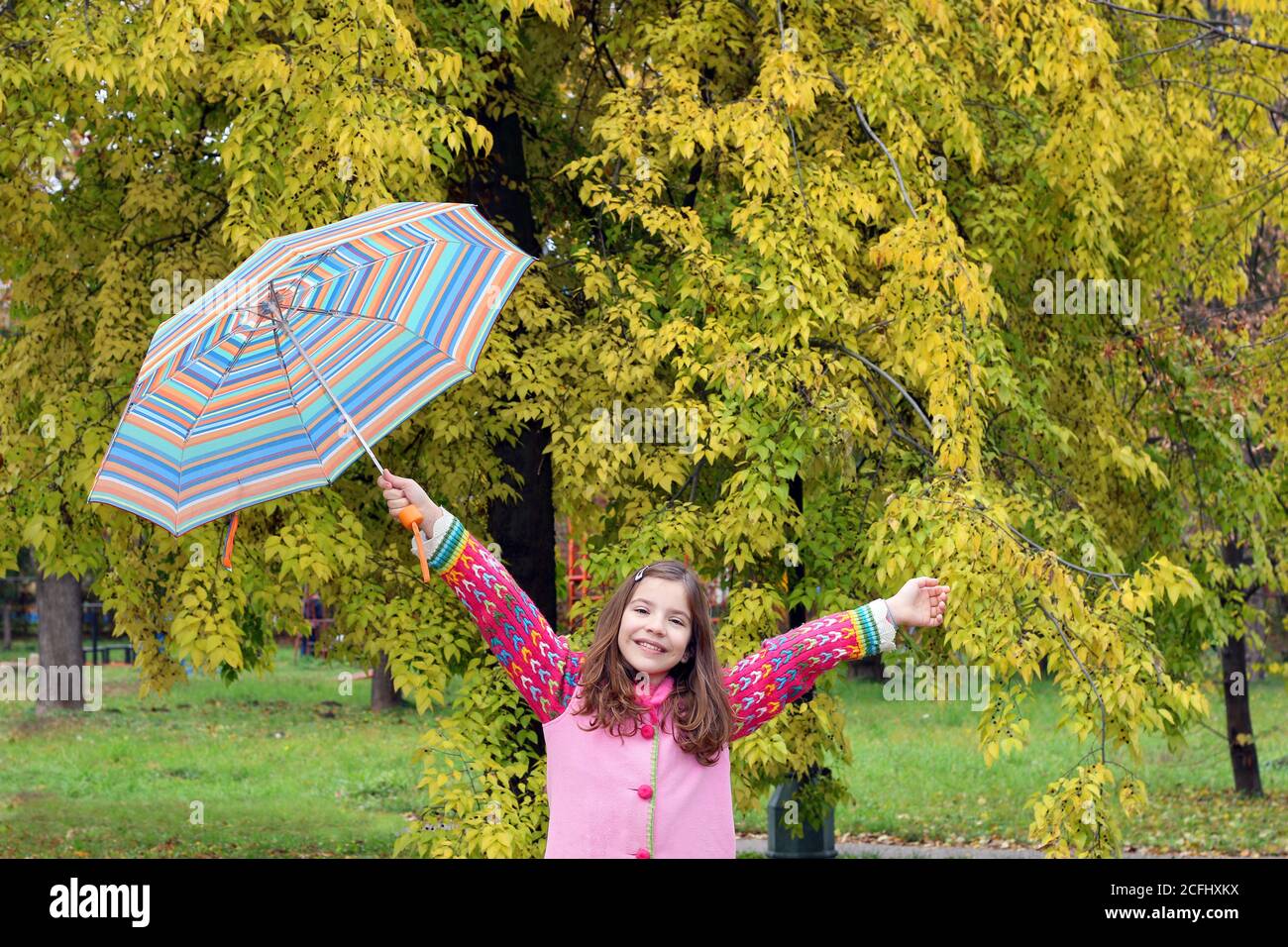 happy little girl with umbrella in park autumn season Stock Photo - Alamy