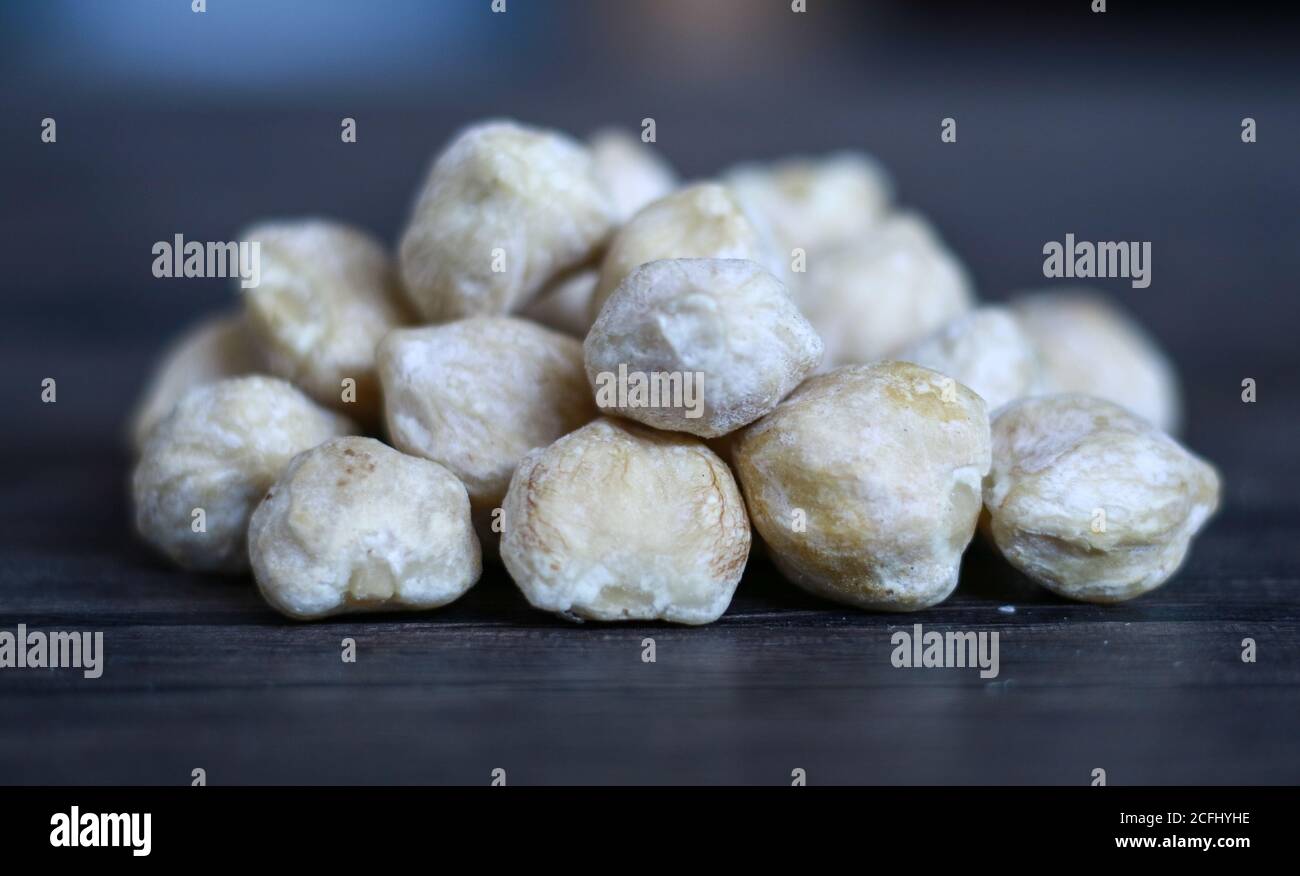 Candlenut or aleurites moluccana on wood background. Stock Photo