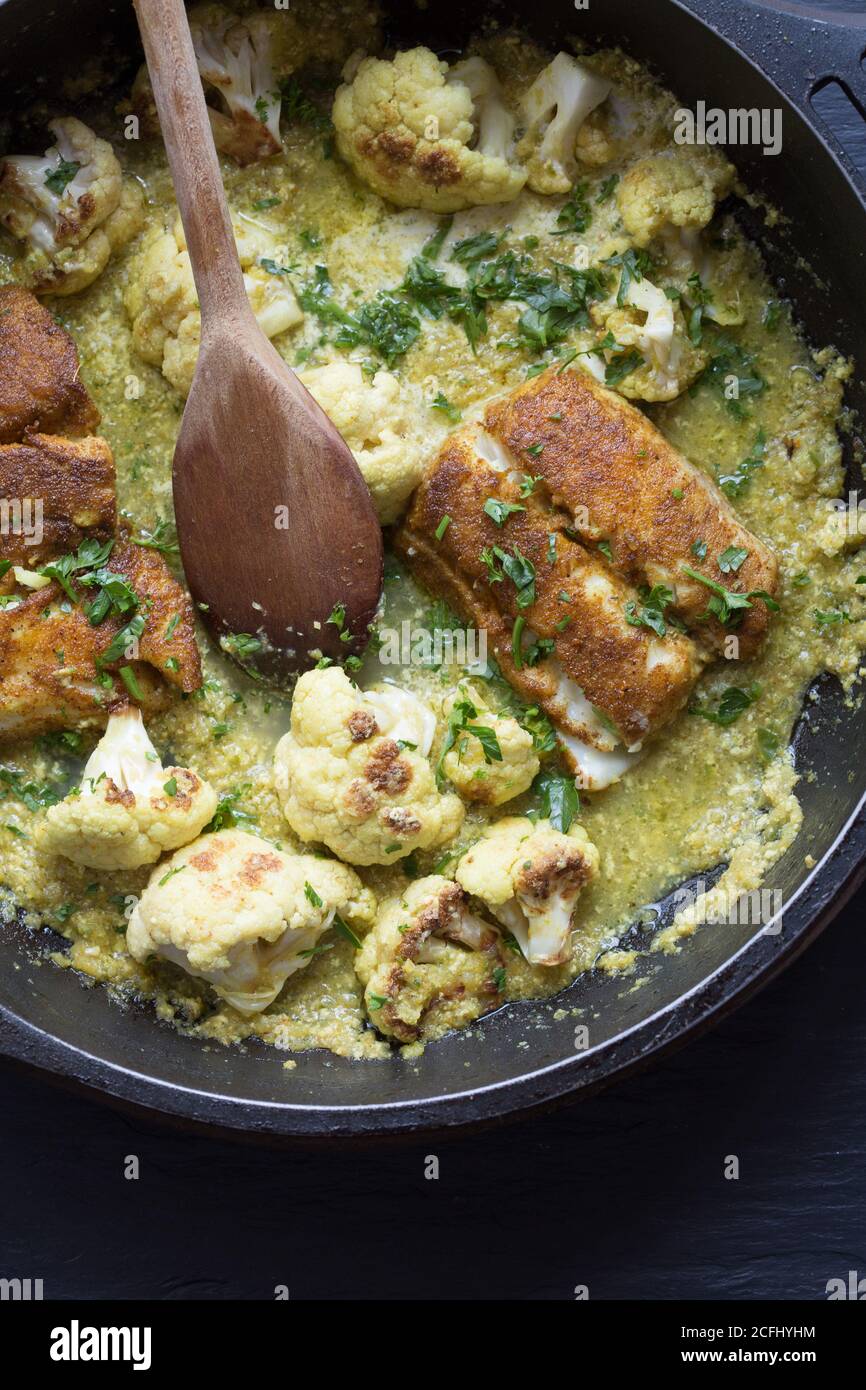 Curried cauliflower with hake in frying pan Stock Photo
