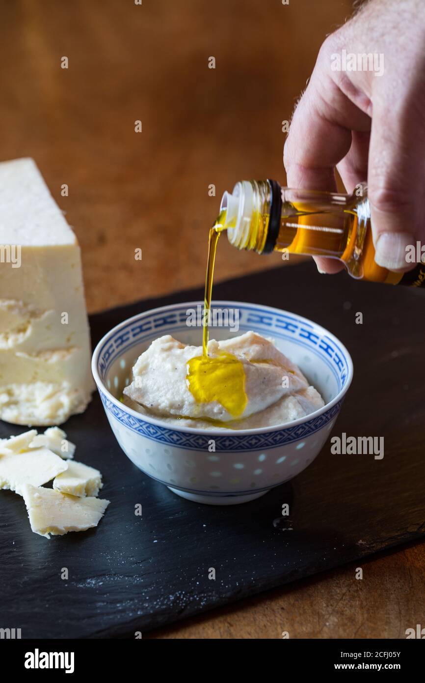 Cauliflower puree with truffle oil being drizzled over it Stock Photo