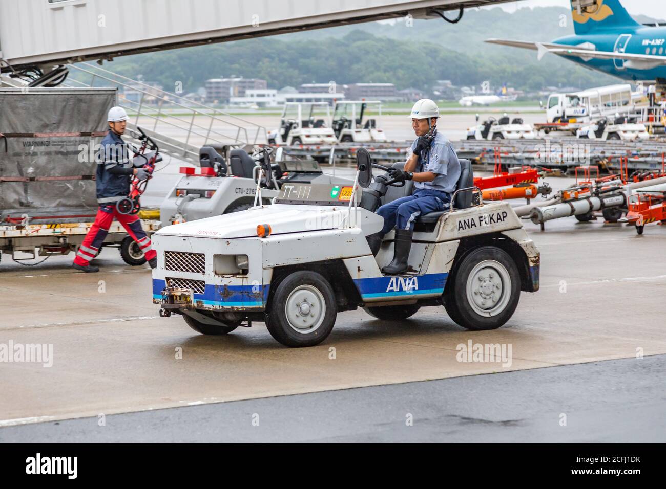 Fukuoka, Japan - 14 July 2019 - Airport baggage handler drives a baggage truck puller at Fukuoka airport in Japan on July 14, 2019 Stock Photo