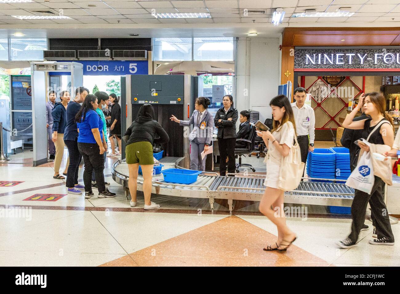 Chiang Mai, Thailand - 14 July 2019 - People wait for their belongings to come out from the airport security scanner at the airport entrance in Chiang Stock Photo