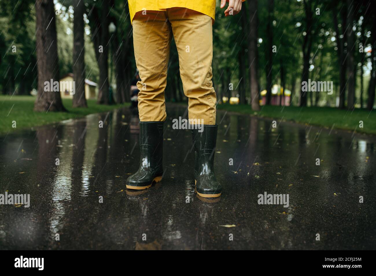 Male person in rain cape and rubber boots Stock Photo