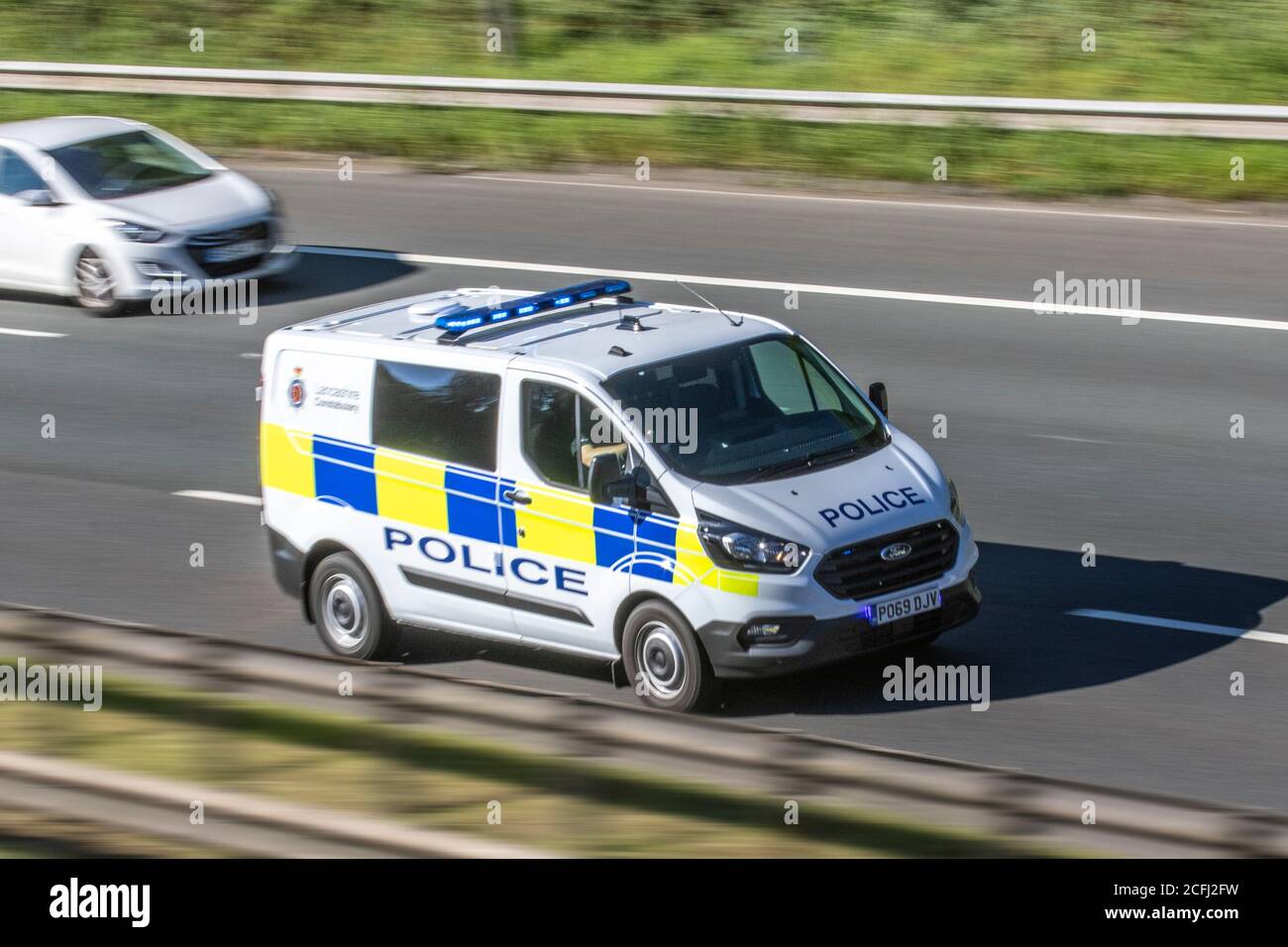 Police Ford Mondeo van; UK Vehicular traffic, transport, modern, emergency response cars, flashing blue lights south-bound on the M6 motorway highway. UK Stock Photo