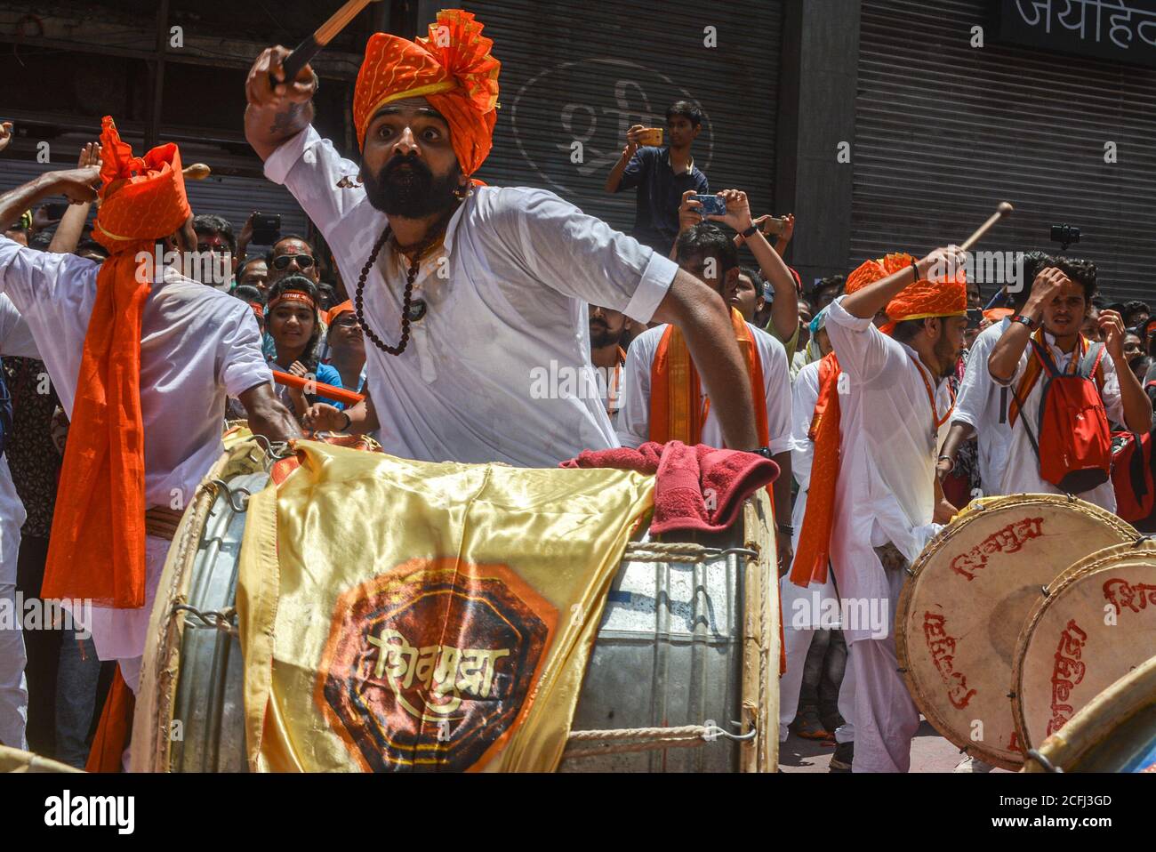 Pune, India - September 4, 2017: Member of Shivmudra Dhol Tasha Pathak looking aggressively while playing dhol. A Person playing dhol passionately on Stock Photo