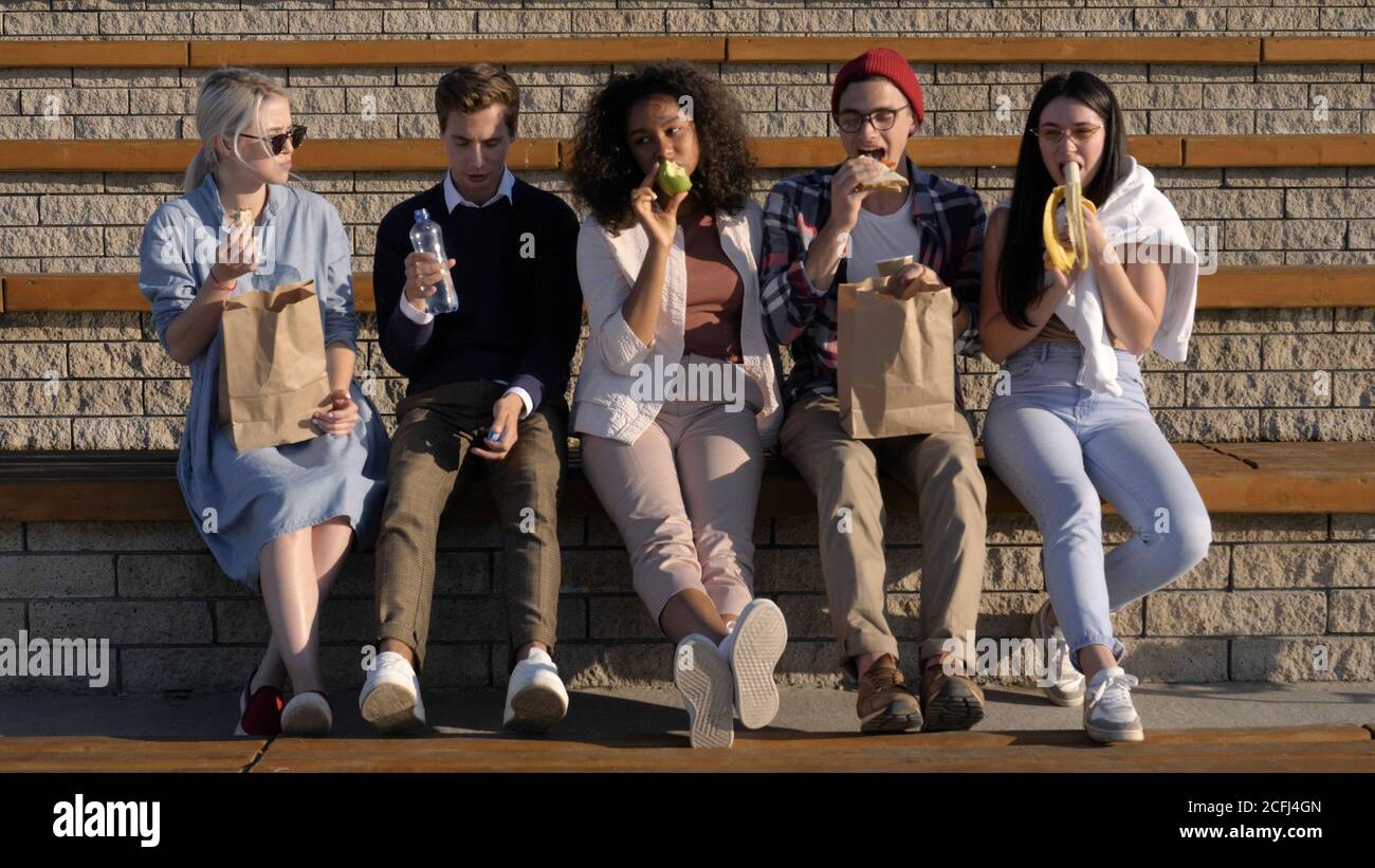 Students having lunch break outside the university. Stock Photo