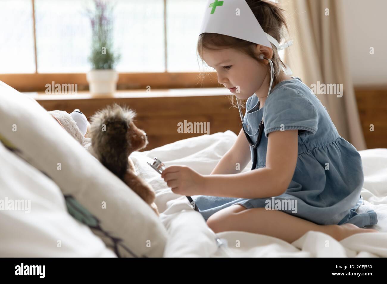 Nurse kid use stethoscope listen heartbeat of soft hedgehog toy Stock Photo