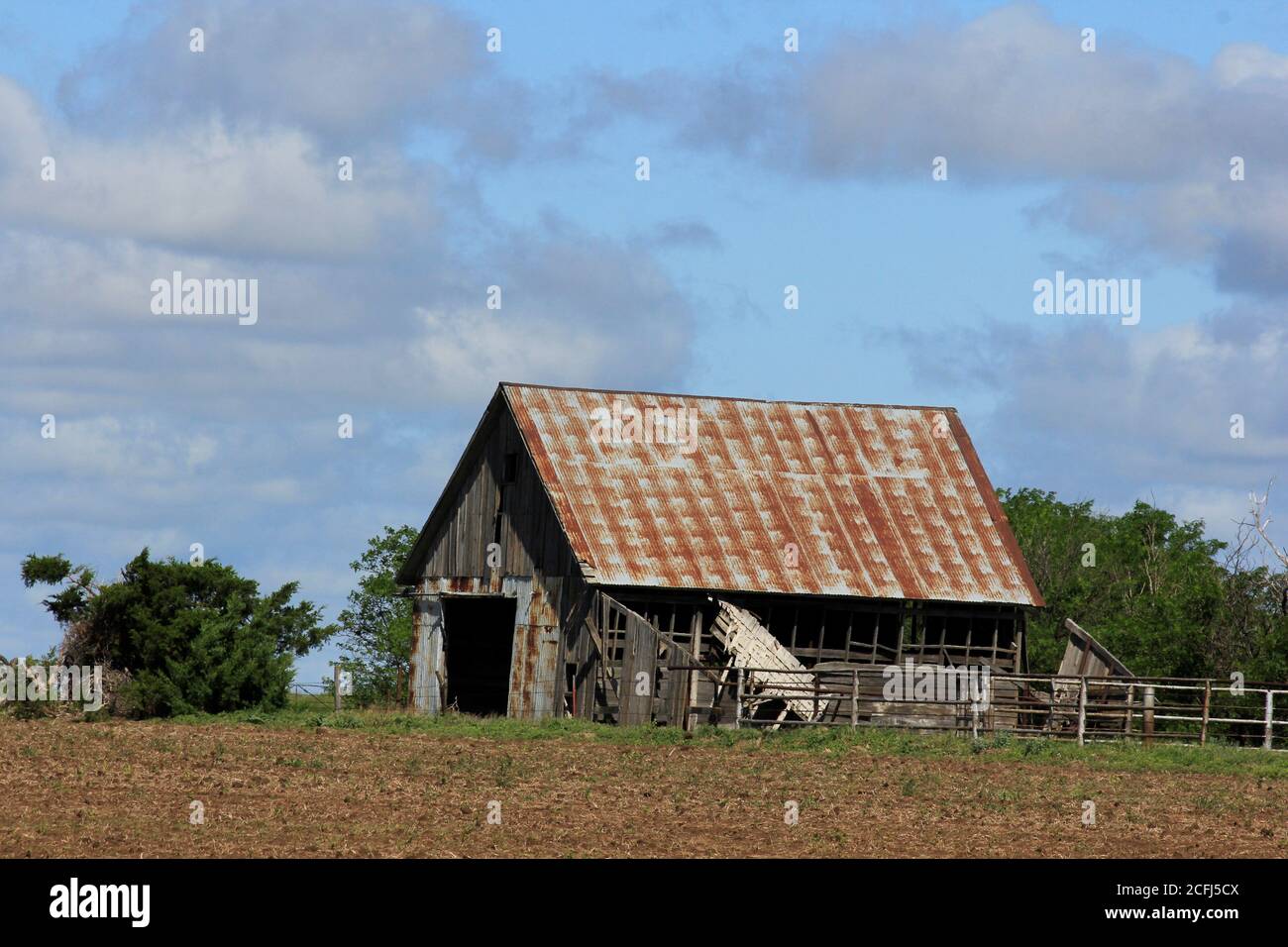 Kansas Country barn with a corral,tree's,blue sky and white cloud's out in the country. Stock Photo