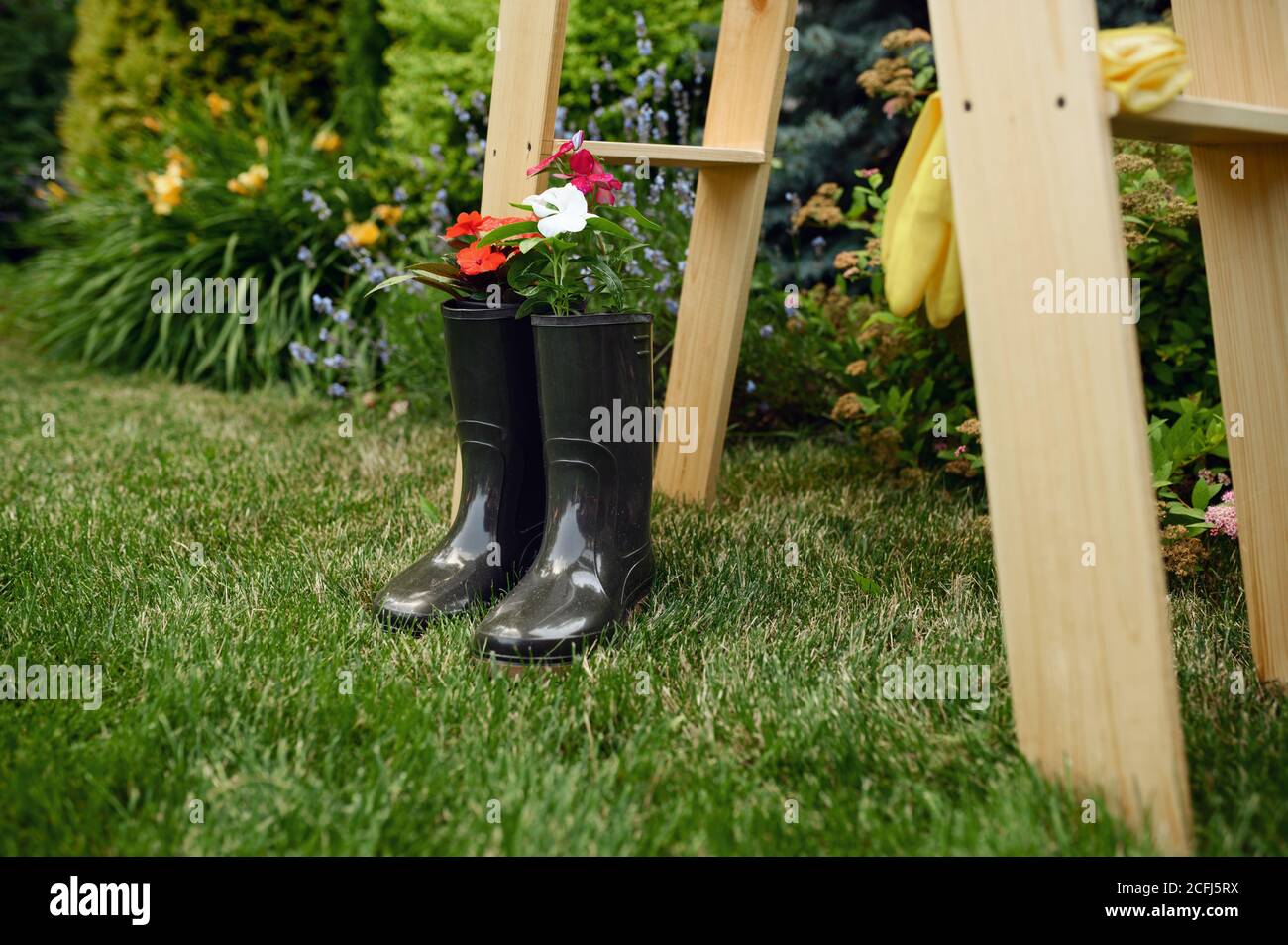 Gardening tools, flowers in rubber boots, nobody Stock Photo - Alamy