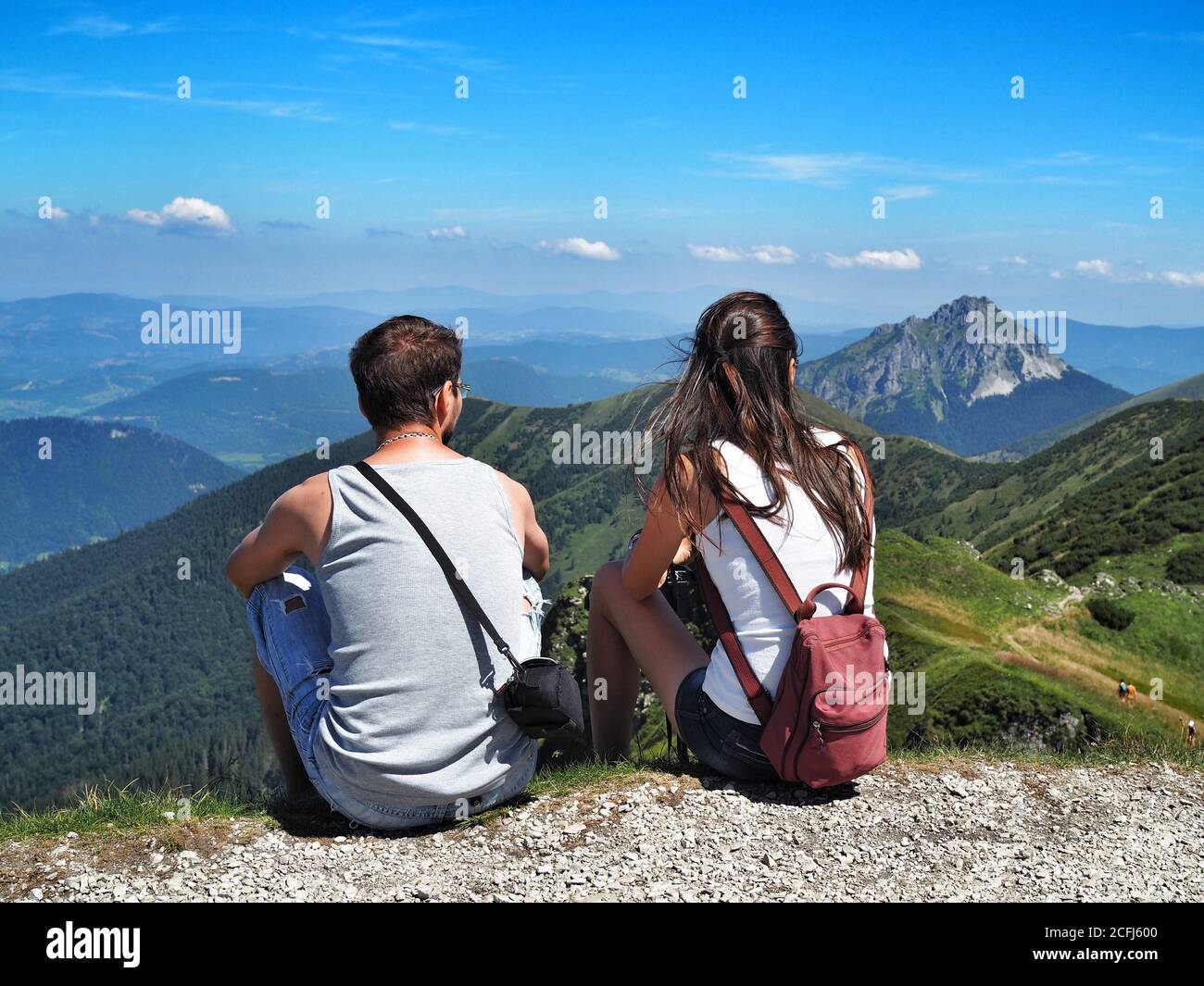 LITTLE FATRA, SLOVAKIA - 08/03/2018: Couple of young man and woman looking at Stony peak Big Rozsutec in The Little Fatra National Park. Stock Photo