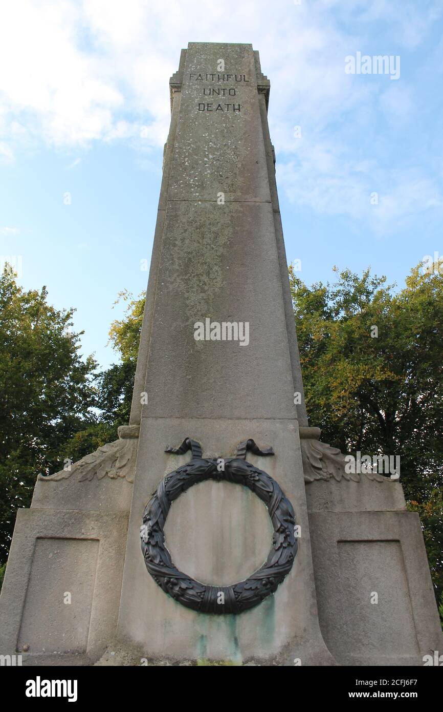 Close up of Upholland War Memorial grade 11 listed constructed from Portland Stone with a bronze wreath and inscribed with faithful until death Stock Photo