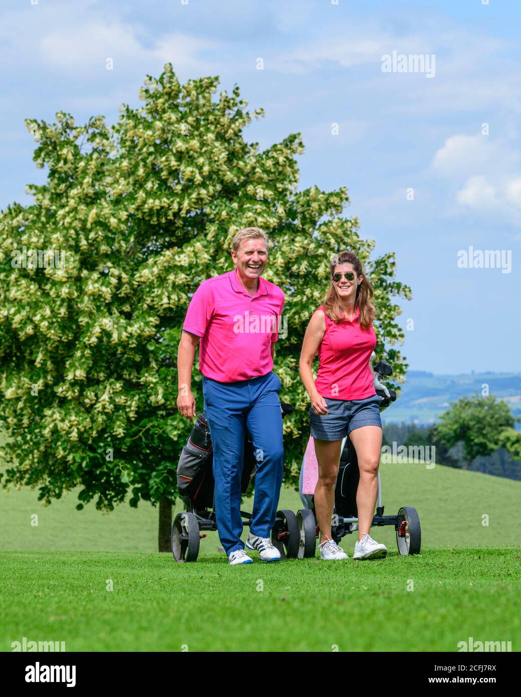 Couple on the way on golf course Stock Photo