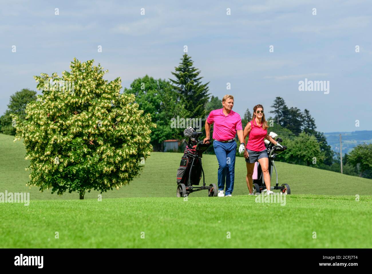 Couple on the way on golf course Stock Photo