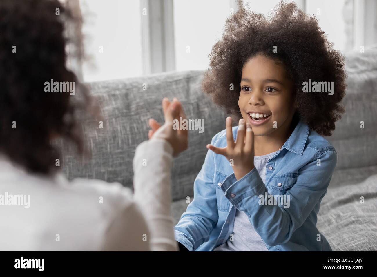 Mixed race little girl learning correct sounds pronunciation. Stock Photo