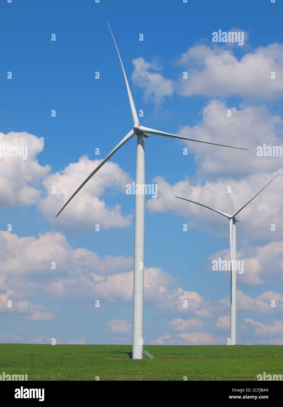 Wind turbine under blue sky and clouds Stock Photo - Alamy