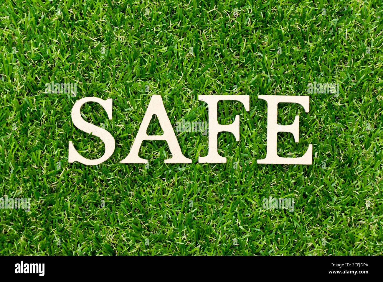 Wood letter in word safe on green grass background Stock Photo - Alamy