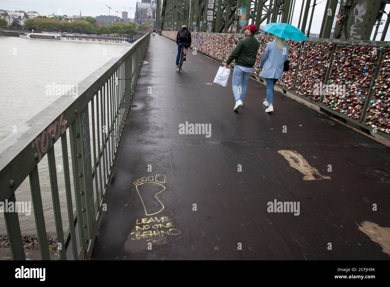 graffiti 'Leave no one behind'  on the Hohenzollern railway bridge, view to the cathedral, Cologne, Germany.  Graffiti 'Leave no one behind'  auf der Stock Photo