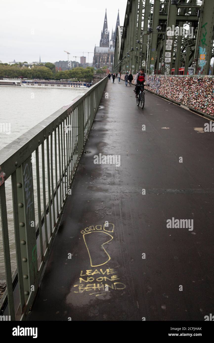 graffiti 'Leave no one behind'  on the Hohenzollern railway bridge, view to the cathedral, Cologne, Germany.  Graffiti 'Leave no one behind'  auf der Stock Photo