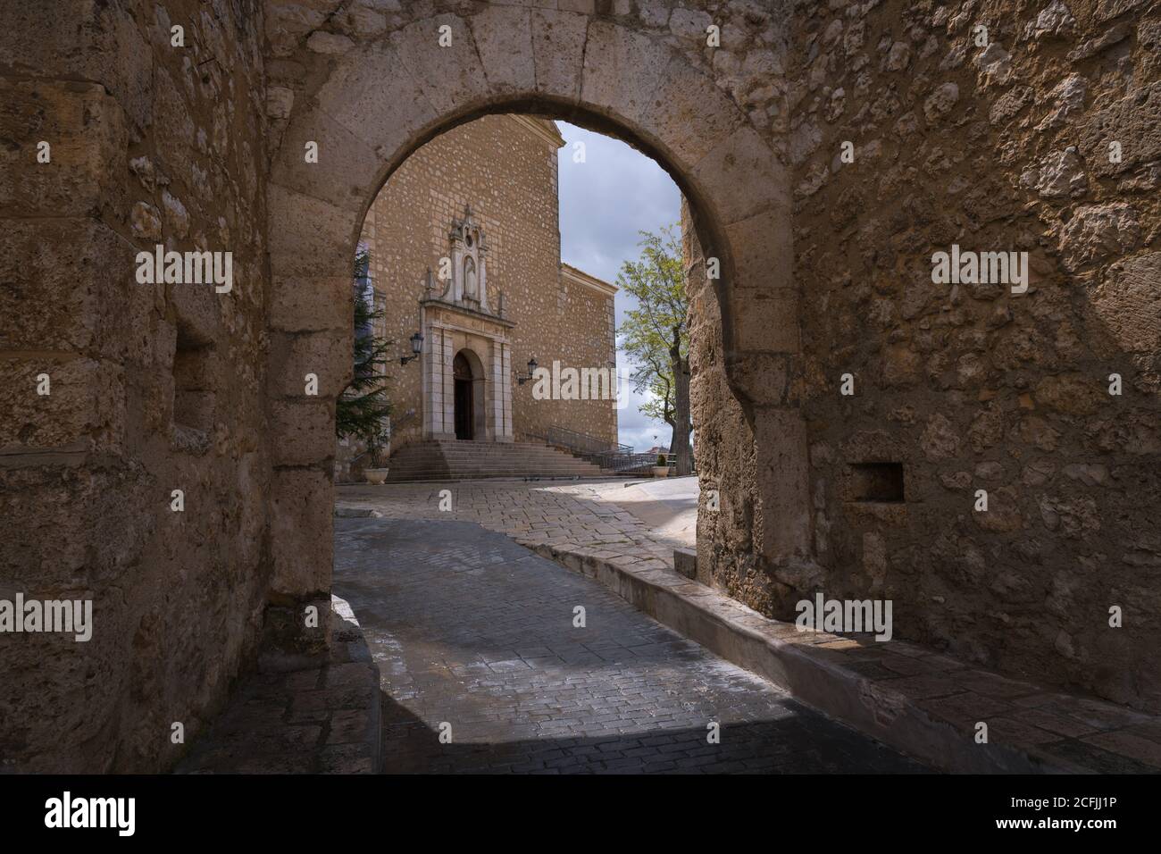 View of the main facade of the Church of Our Lady of the Assumption through the entrance portico to the church compound in Tarancón, Cuenca, Spain Stock Photo