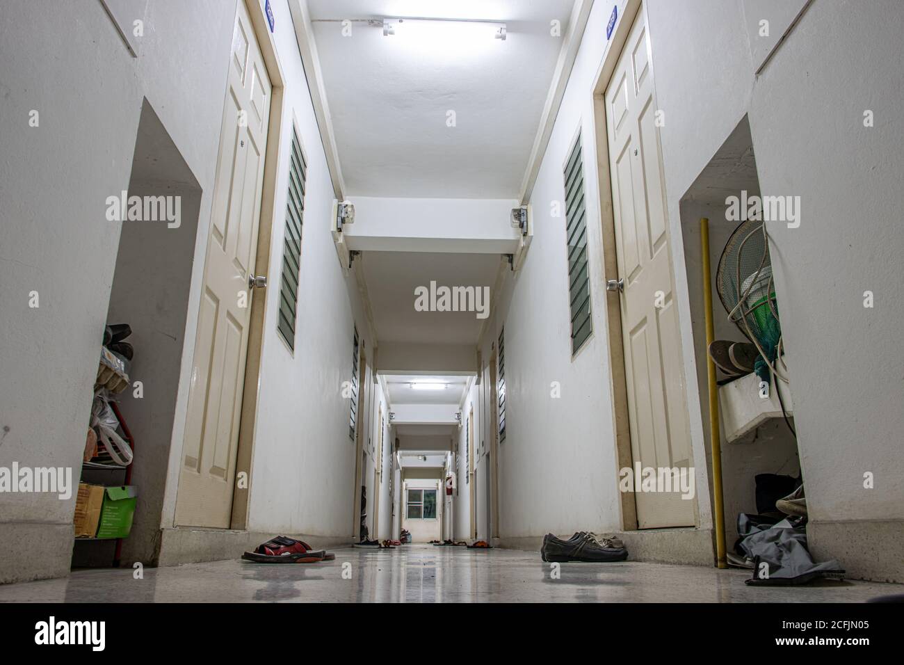 The empty hallway in an apartment house with shoes beside the doors. Stock Photo