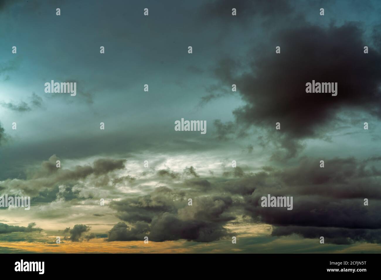 Sunset sky and gray and golden clouds. Gray sky and fluffy clouds. Thunder and storm sky. Sad and moody sky. Dead abstract background. Cloudscape. Stock Photo