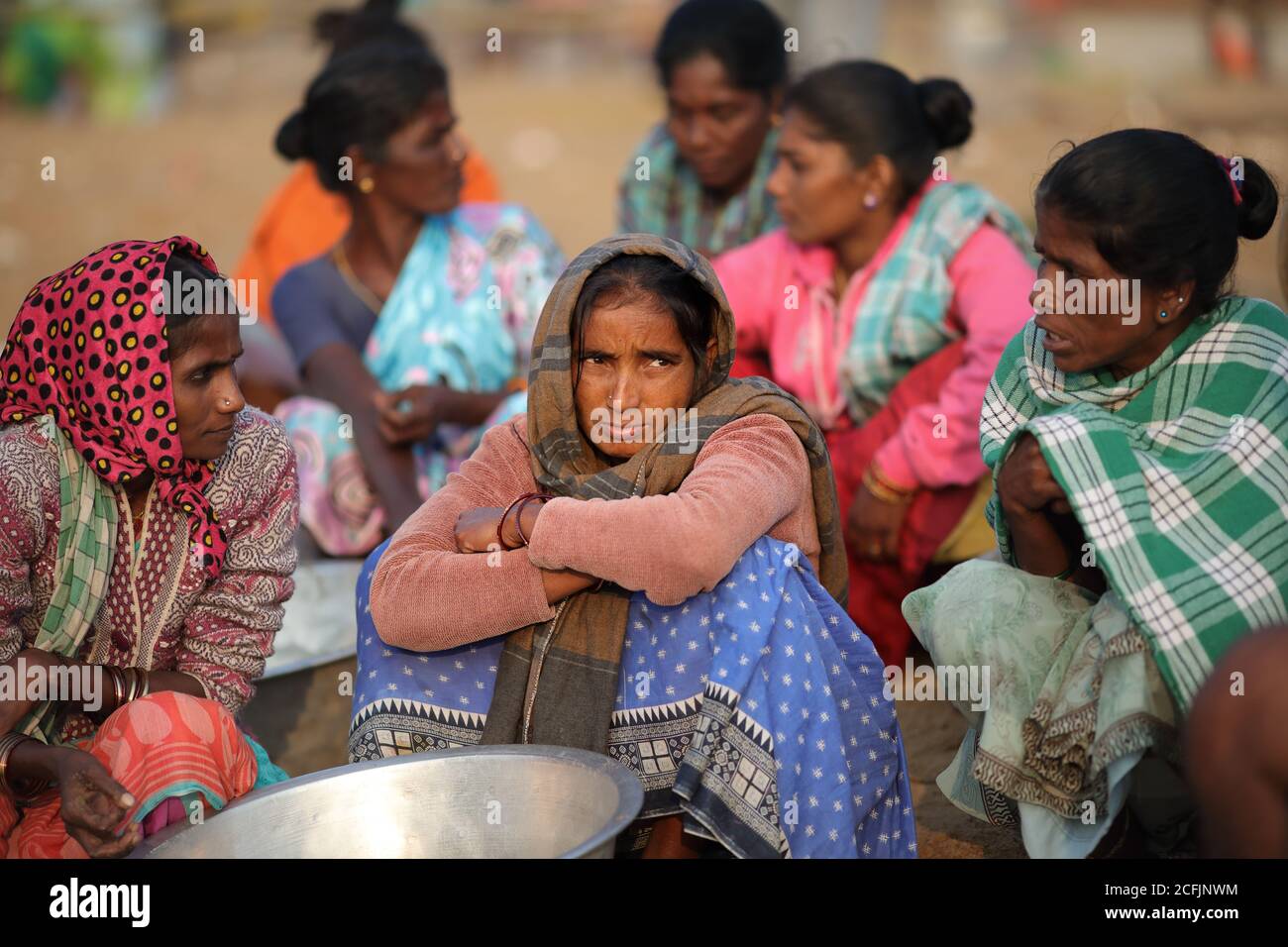 Market women wait for fish on the beach near the traditional fishing colony in Puri, Odisha, India Stock Photo