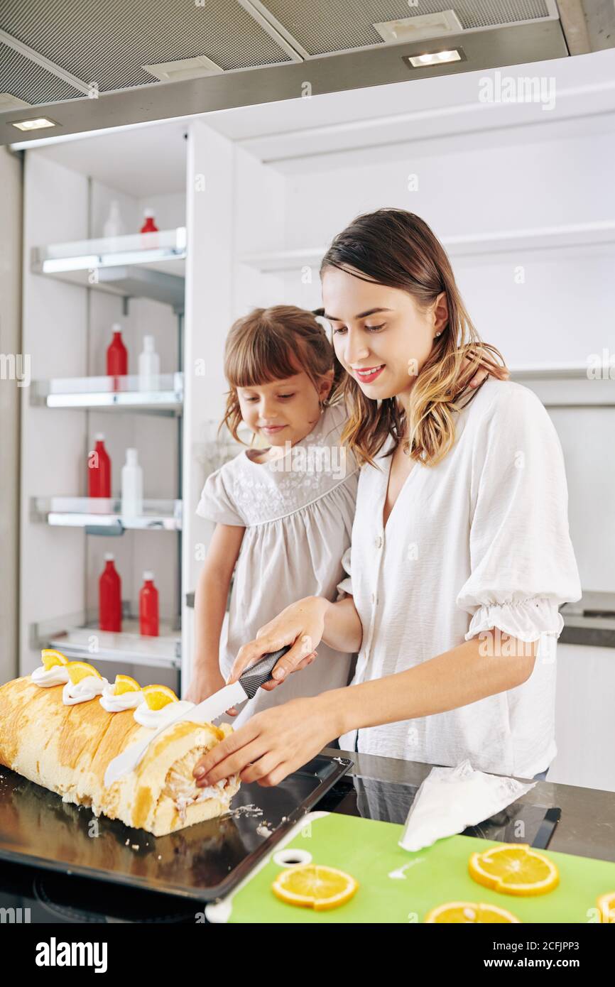 Cutting slice of biscuit roll Stock Photo