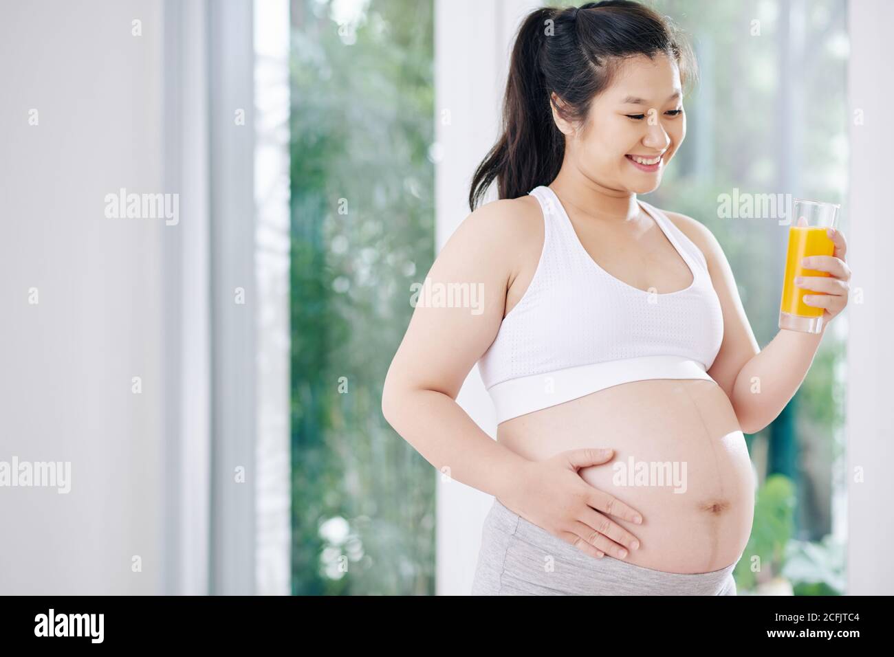 Pregnant woman drinking orange juice Stock Photo Alamy