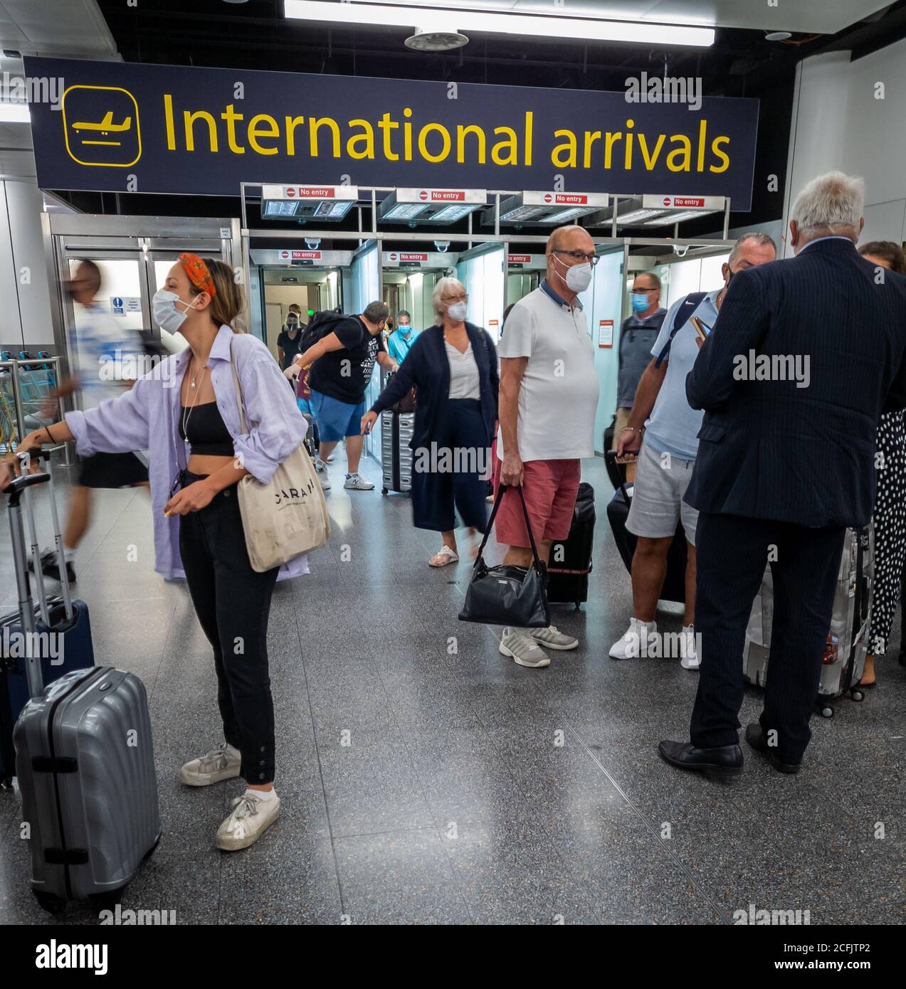 Air passengers emerging from the international arrivals gates in Gatwick airport north terminal. Stock Photo
