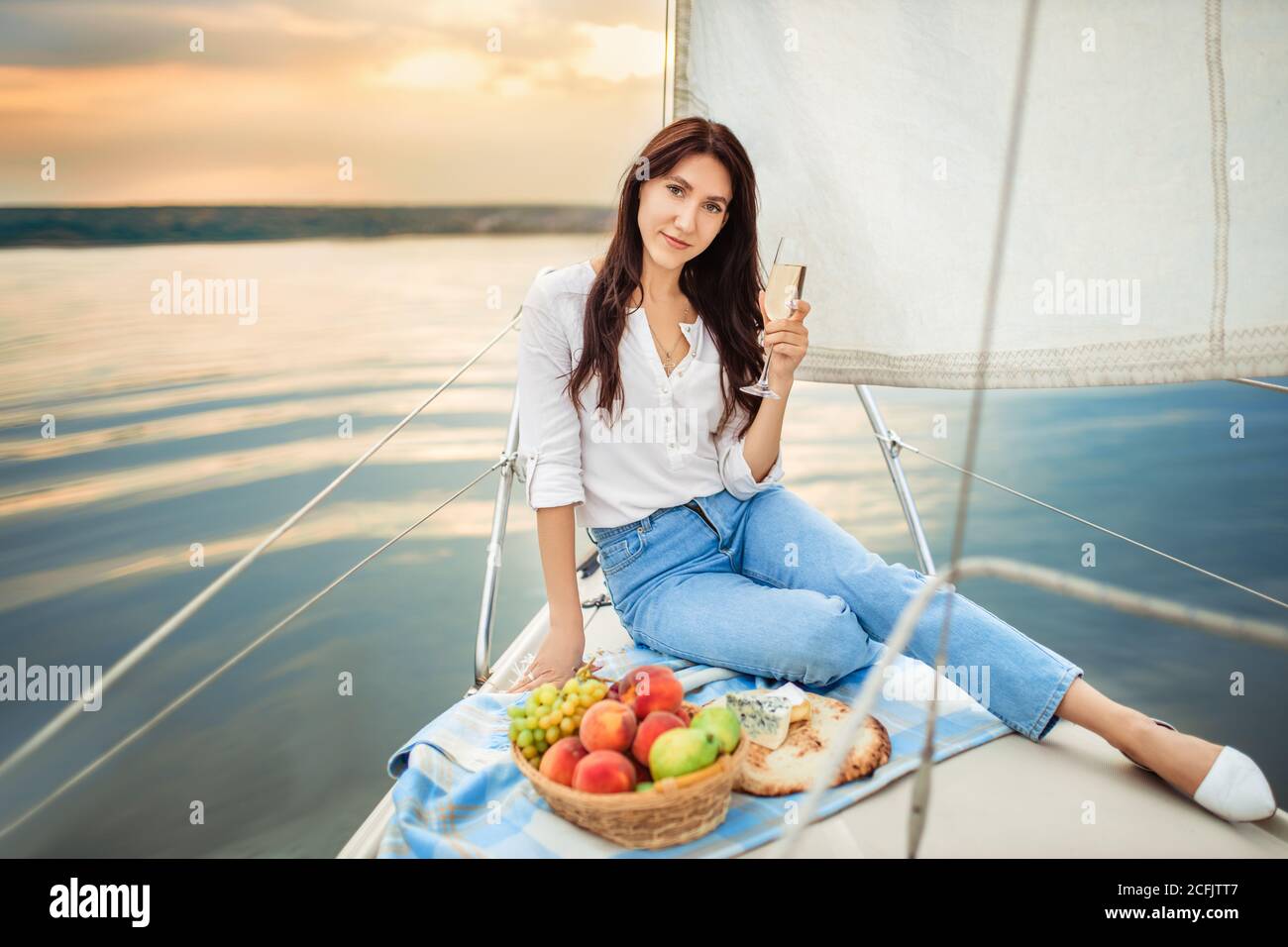 woman with glass of champagne resting on yacht Stock Photo