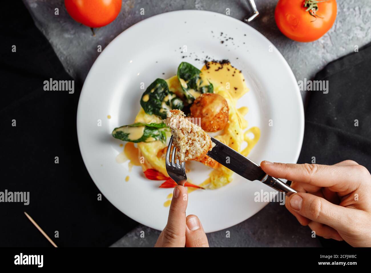 cheese balls in the sauce. with fork, knife in hand Stock Photo