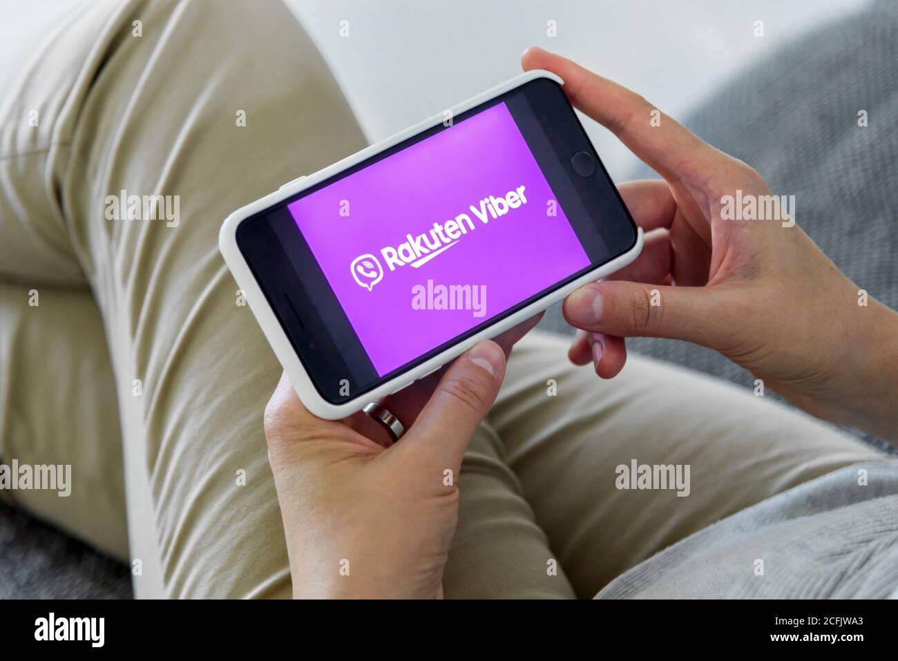 Woman holding a iPhone 7 with client messaging and voice service Viber on the screen. Stock Photo
