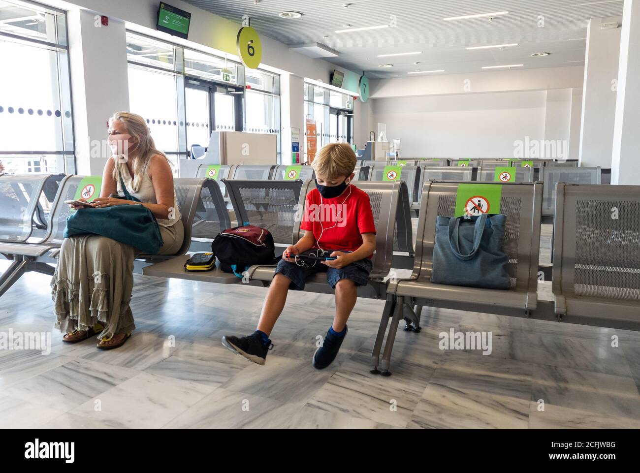 Holiday makers waiting for their return flight in the departure lounge of Aktion airport. Stock Photo