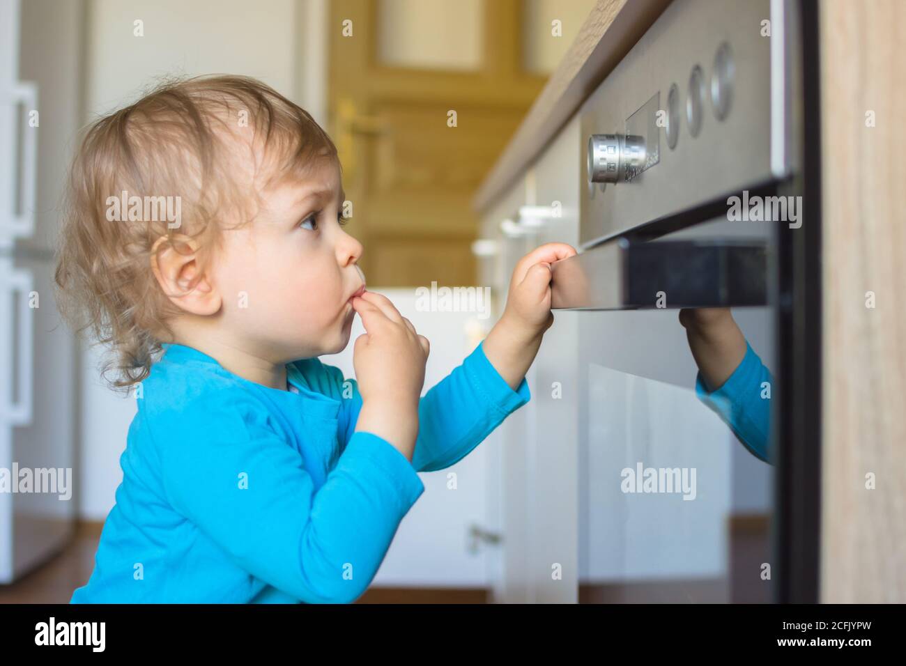 Child touches hot stove in the home. Dangerous situation in the kitchen.  Red-hot surface of hob Stock Photo by ©rbkomar 416451342