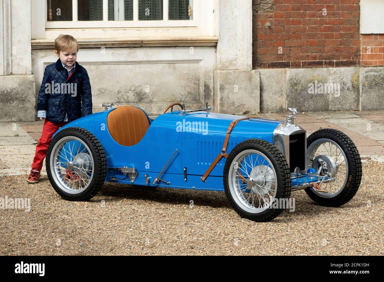 Young boy looking at minature Amilcar at the Hampton Court Concours 2020 Stock Photo
