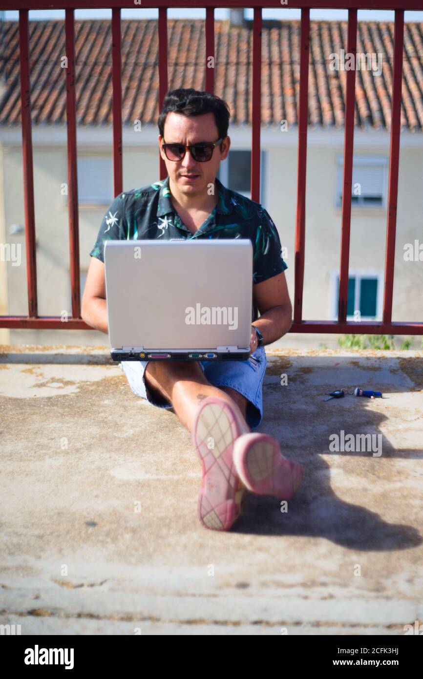Man teleworking online outdoors with a laptop computer. Stock Photo