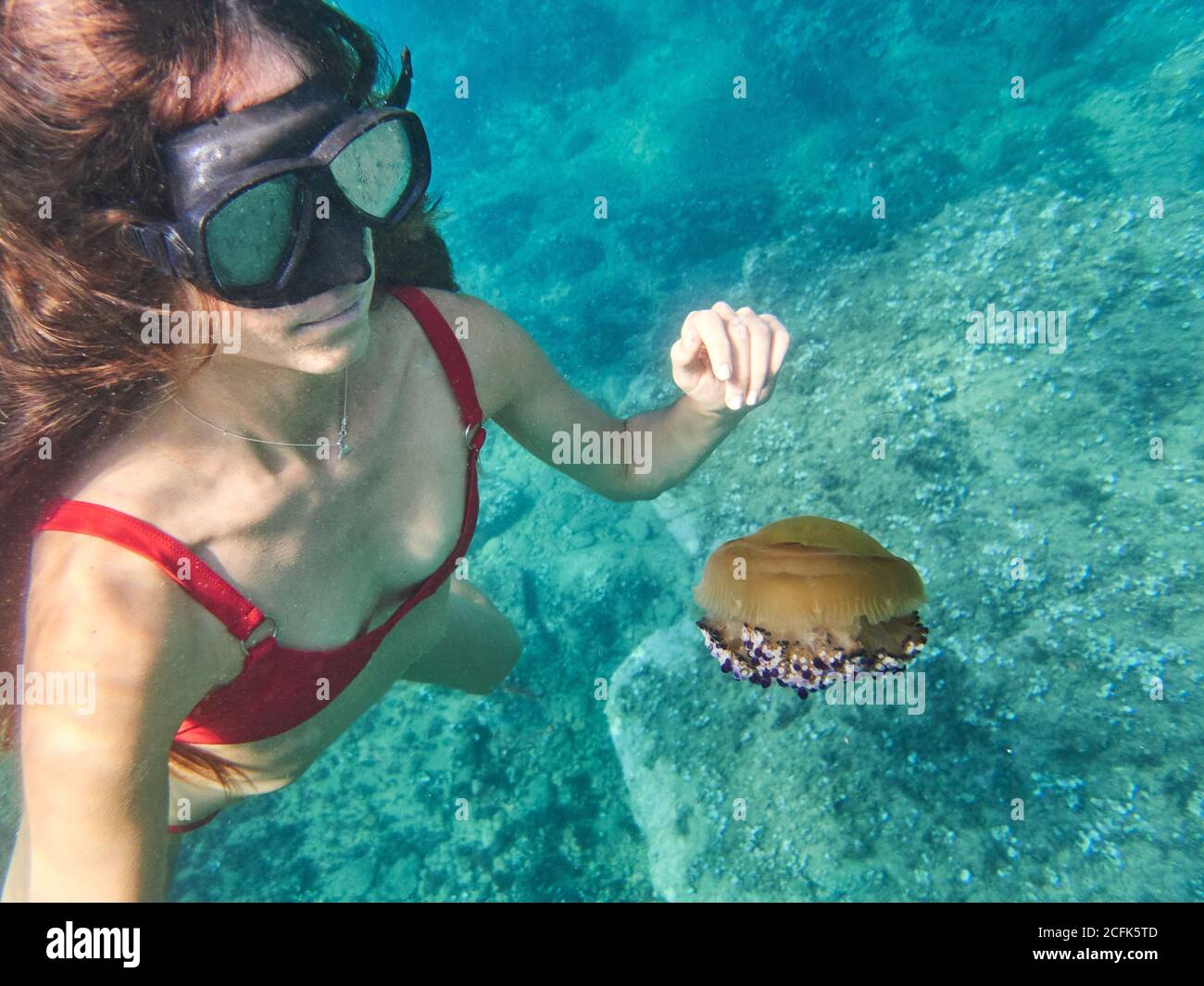 unrecognizable young Woman in diving mask swimming in deep transparent