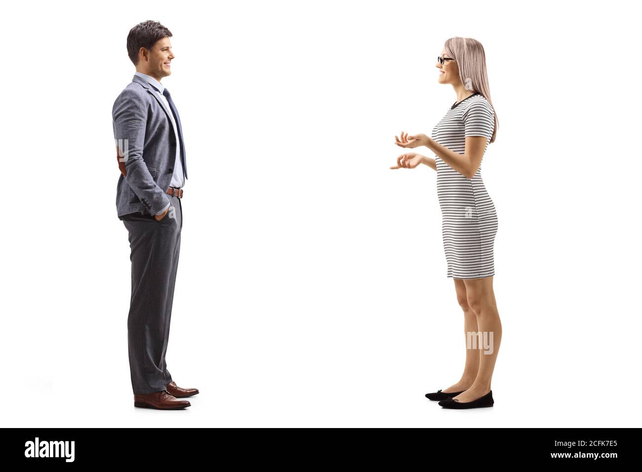 Full length profile shot of a young woman having a conversation with a man isolated on white background Stock Photo