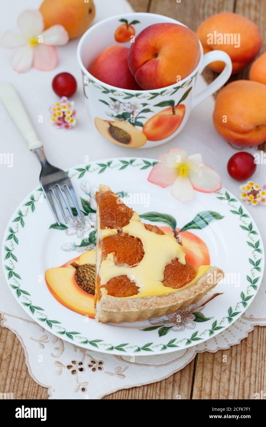 apricot tart on the plate and fresh apricots in the cup Stock Photo