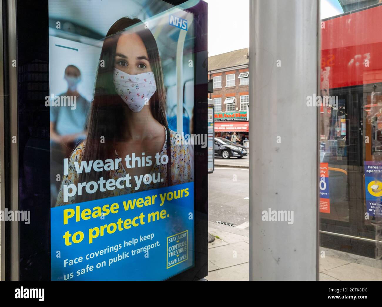 Billboard advertisement by the NHS telling people to wear a face covering as a Covid-19 pandemic safety measure. Stock Photo