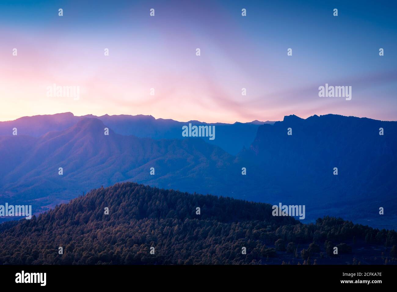 Majestic landscape of mountain range and valley with trees under blue ...